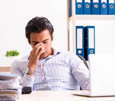 Ofiste oturan genç bir çalışan.