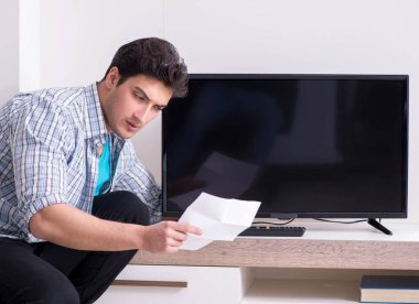 Bozuk televizyonu tamir etmeye çalışan adam