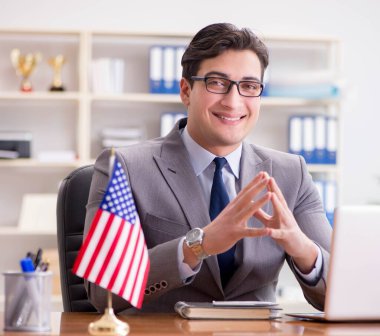 Ofisinde Amerikan bayrağı taşıyan bir iş adamı