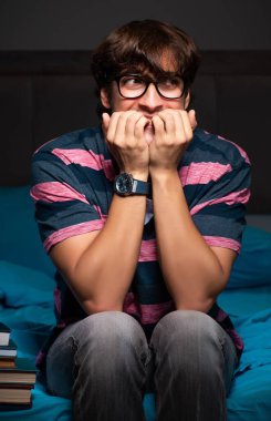 Geceleri sınava hazırlanan yakışıklı bir genç.