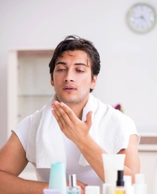 Tuvaletteki genç yakışıklı adam hijyen konseptinde.