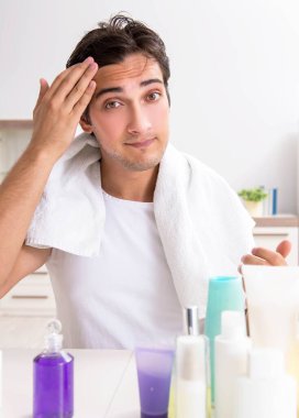 Tuvaletteki genç yakışıklı adam hijyen konseptinde.