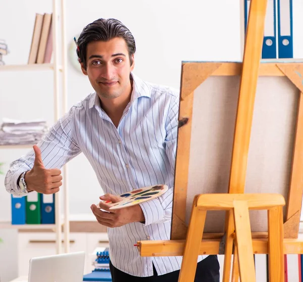 Joven empleado guapo disfrutando de la pintura en la oficina — Foto de Stock
