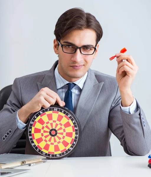 Businessman with dartboard sitting at the office — Stock Photo, Image