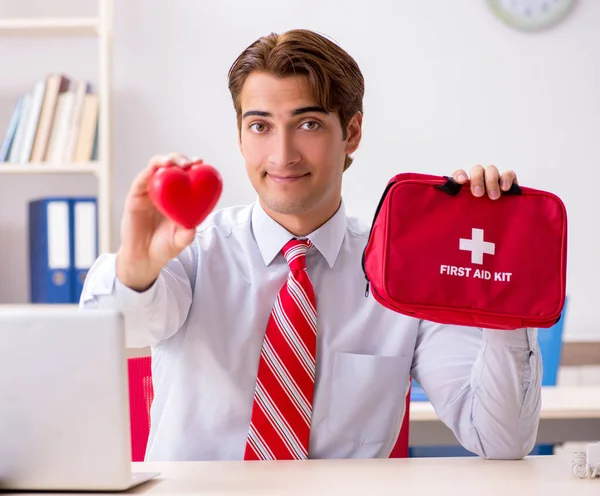 Man med första hjälpen kit på kontoret — Stockfoto