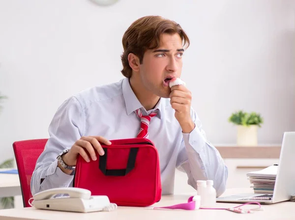 Man with first aid kit in the office