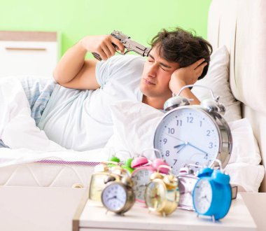 Genç adam sabahın köründe uyanmakta zorlanıyor.