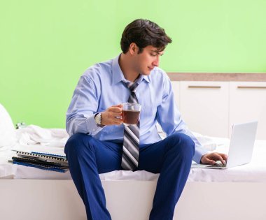 Otel odasında fazla mesai yapan bir iş adamı.