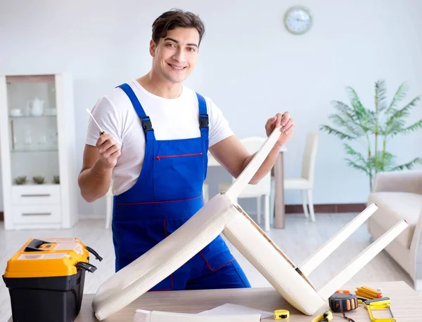 Man repareert stoel in de kamer — Stockfoto