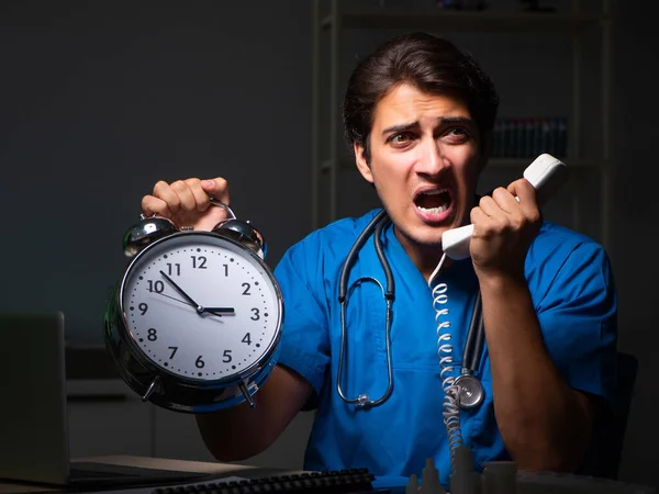 Joven médico guapo trabajando turno de noche en el hospital —  Fotos de Stock