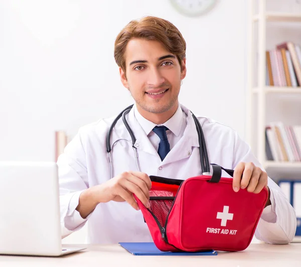 Jovem médico com kit de primeiros socorros no hospital — Fotografia de Stock