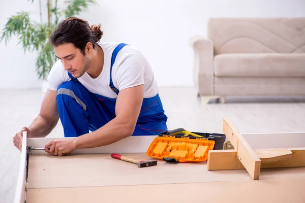 Fiatal férfi vállalkozó telepítése bútorok otthon — Stock Fotó