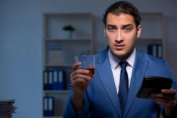 Alcohol verslaafde zakenman die laat op kantoor werkt — Stockfoto