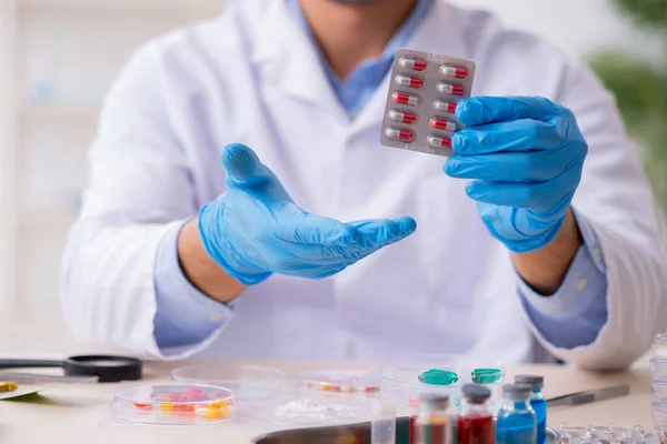 Young male lab assistant in drug synthesis concept — Stock Photo, Image