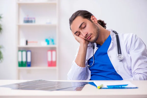 Νεαρός άνδρας γιατρός είναι κουρασμένος μετά τη νυχτερινή βάρδια — Φωτογραφία Αρχείου