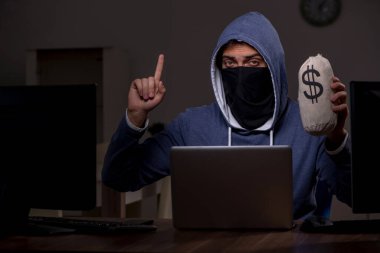 Erkek bilgisayar korsanı, güvenlik duvarını geç saatlerde hackliyor.