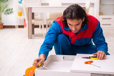 Genç erkek marangoz içeride çalışıyor.