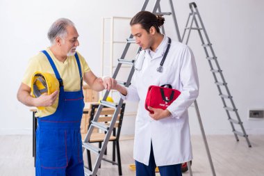 İlk yardım konseptinde genç erkek doktor ve yaşlı müteahhit.