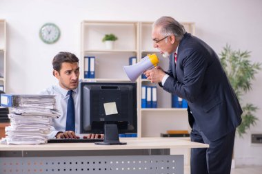 Eski patron ve genç erkek çalışan ofiste.