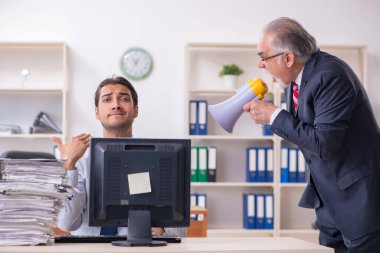 Eski patron ve genç erkek çalışan ofiste.