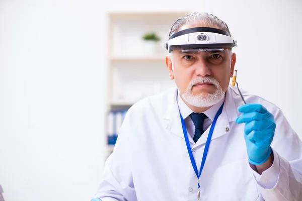 Homem velho criminologista especialista que trabalha no laboratório para provas — Fotografia de Stock