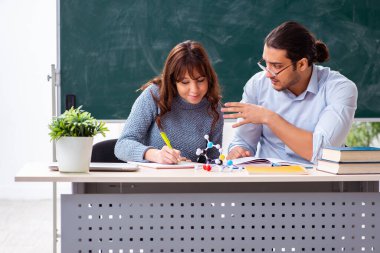 Genç bayan öğrenci ve erkek öğretmen sınıfta.