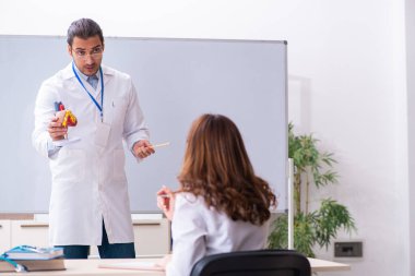 Genç erkek doktor kardiyolog ve sınıftaki bayan öğrenci.