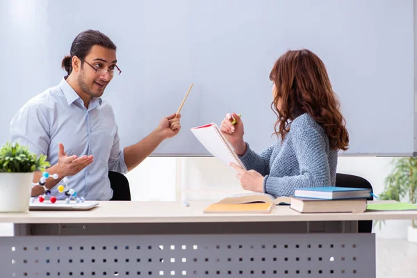 Young female student and male teacher in the classroom — Stock Photo, Image