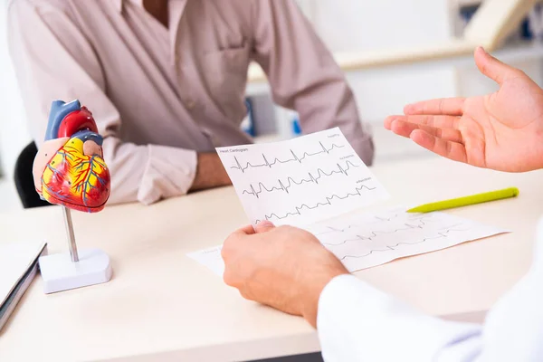 Yaşlı adam genç doktor kardiyoloğu ziyaret ediyor. — Stok fotoğraf