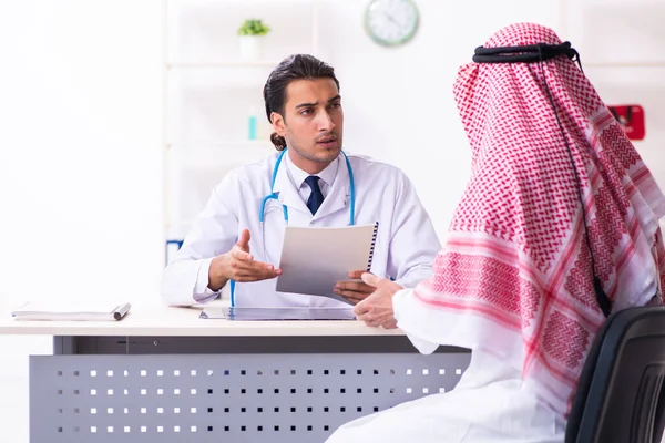 Old male arab visiting young male doctor — Stock Fotó