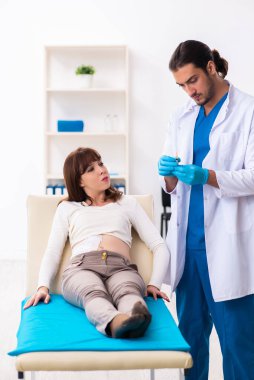 Yaralı genç kadın genç erkek doktoru ziyaret ediyor.