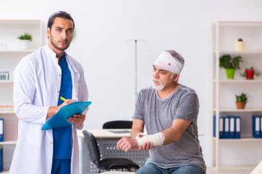 İlk yardım konseptinde genç erkek doktor ve yaşlı hasta.