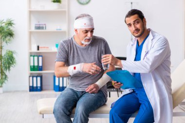 İlk yardım konseptinde genç erkek doktor ve yaşlı hasta.