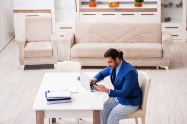 Evden kendini izole etme konseptiyle çalışan genç bir erkek işçi.