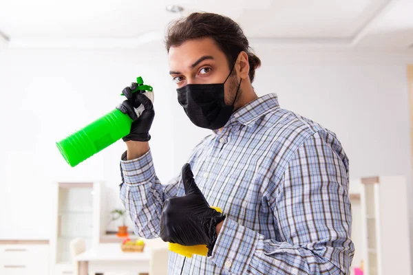 屋内で消毒する若い男性消毒剤 — ストック写真