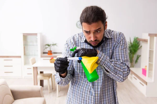 Jovem empreiteiro limpando a casa no conceito coronavírus — Fotografia de Stock