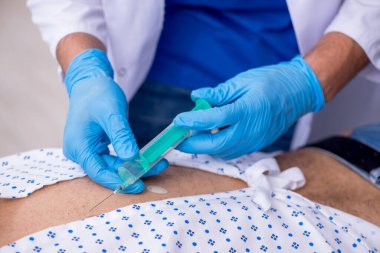 Yaşlı adam genç erkek stajyer doktoru ziyaret ediyor.