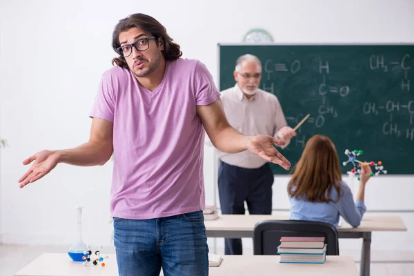 Old chemist teacher and two students in the classroom — Stock Photo, Image
