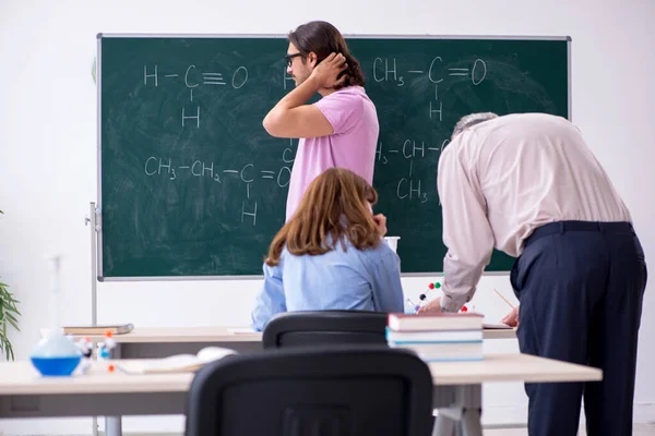 Starý učitel chemie a dva studenti ve třídě — Stock fotografie