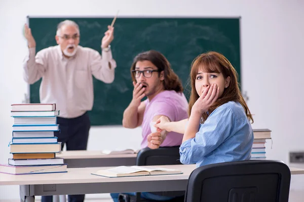 Oude scheikundeleraar en twee leerlingen in de klas — Stockfoto