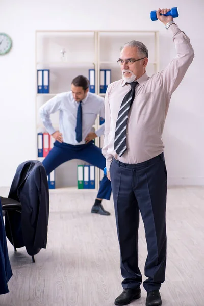 Zwei Mitarbeiter machen körperliche Übungen am Arbeitsplatz — Stockfoto