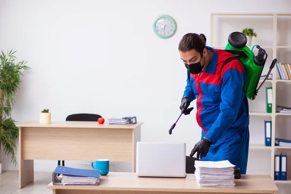 Contratista masculino joven desinfectando oficina — Foto de Stock