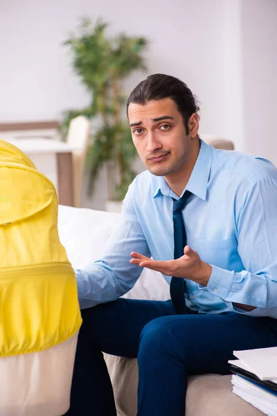 Young businessman looking after newborn at home — Stock Photo, Image