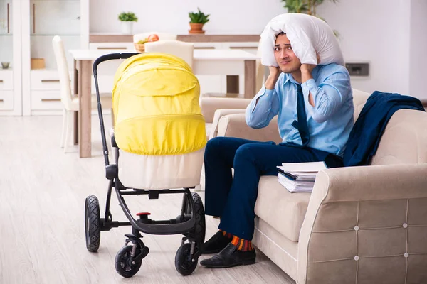 Fiatal üzletember, aki otthon gondozza az újszülöttet. — Stock Fotó