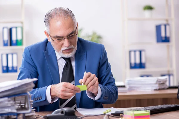 Velho empregado masculino e excesso de trabalho no escritório — Fotografia de Stock