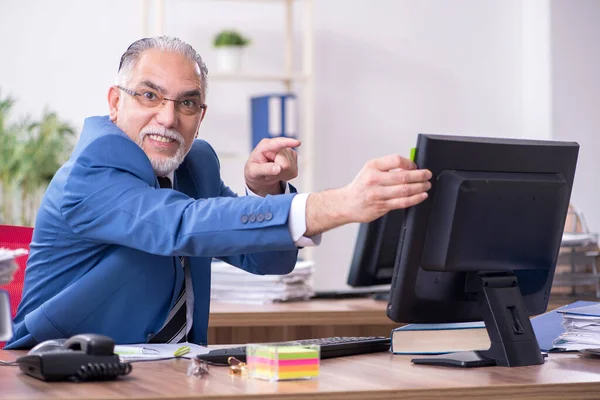 Oude mannelijke werknemer en buitensporig werk op kantoor — Stockfoto