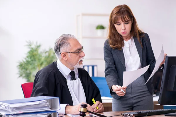 Yaşlı erkek yargıç ve genç sekreteri ofiste.