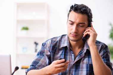 Cep telefonunu tamir eden genç bir teknisyen.