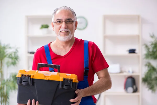Viejo contratista reparando dispositivos domésticos en interiores — Foto de Stock