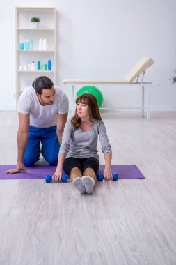 Kişisel koçla spor egzersizleri yapan genç bir kadın.